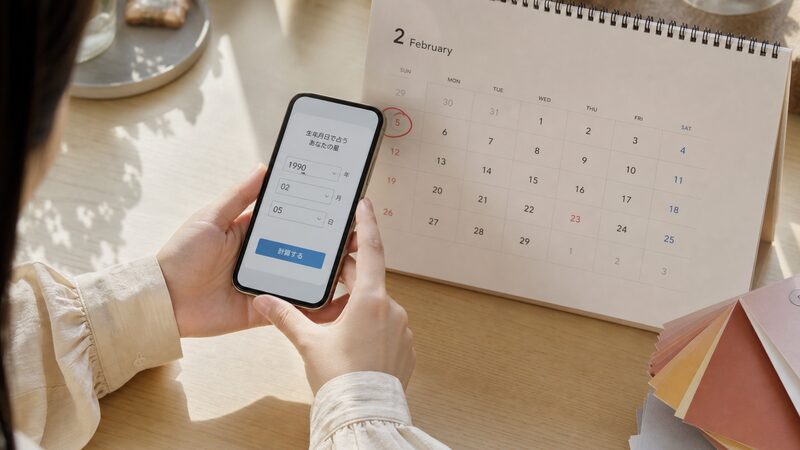 スマホの自動計算ツールと2月のカレンダーで本命星の立春の境目を確認する手元